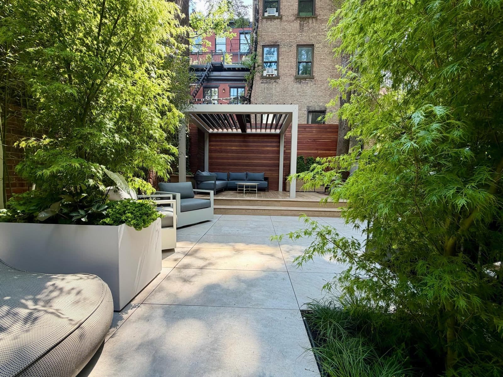 Backyard patio with porcelain pavers, pergola, Ipe fence and elevated deck